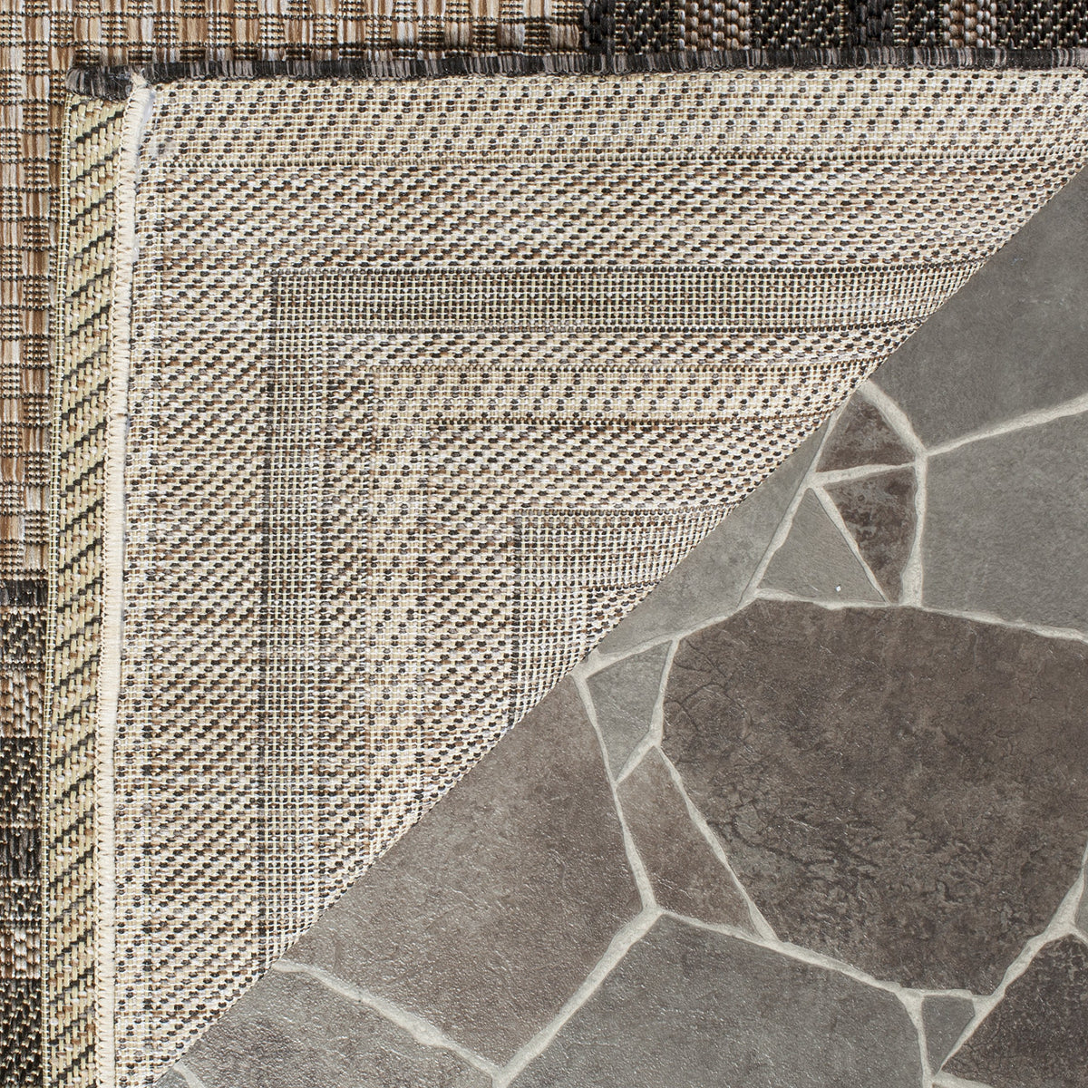 Safavieh Courtyard washable rug natural-black, backyard dining area enhancing outdoor living.
