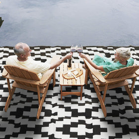 SAND MINE outdoor rug showing corner loops and stakes for secure placement.