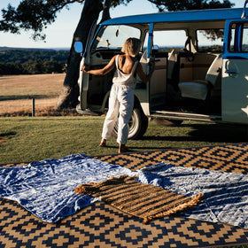 SAND MINE corner loops and stakes keep outdoor rug secure on ground.