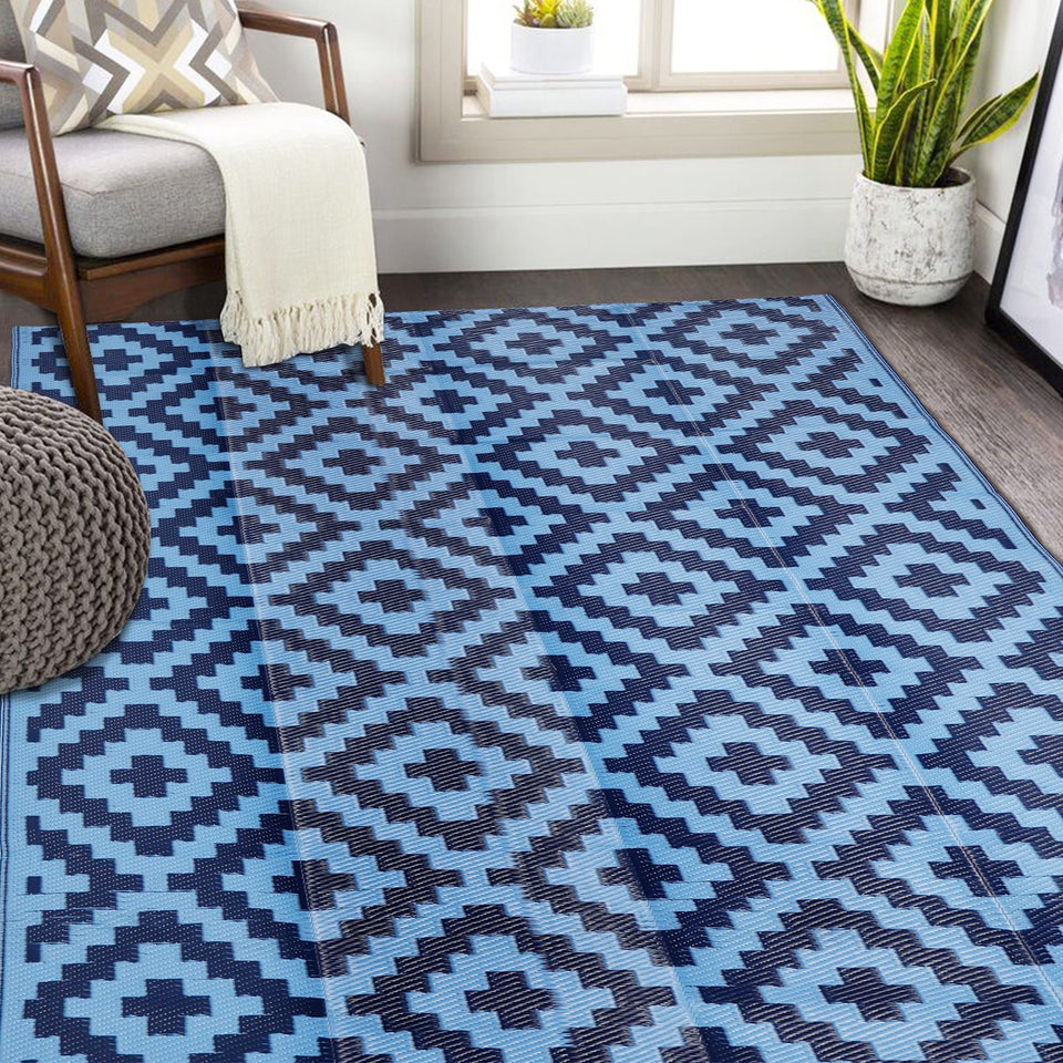 SAND MINE reversible mats in blue on a patio, durable and easy to clean.