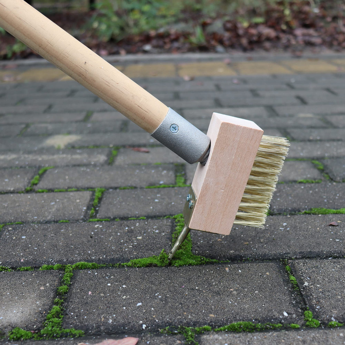 SCRUBIT wired grout cleaner used on pavers for deep weed removal.