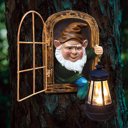Scuyari gnome with solar lantern lighting the garden at night.