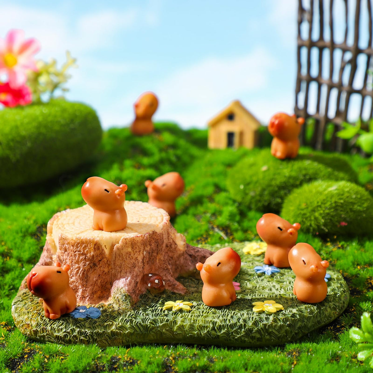 Simgoing capybara figurines in a fairy garden setup for whimsy