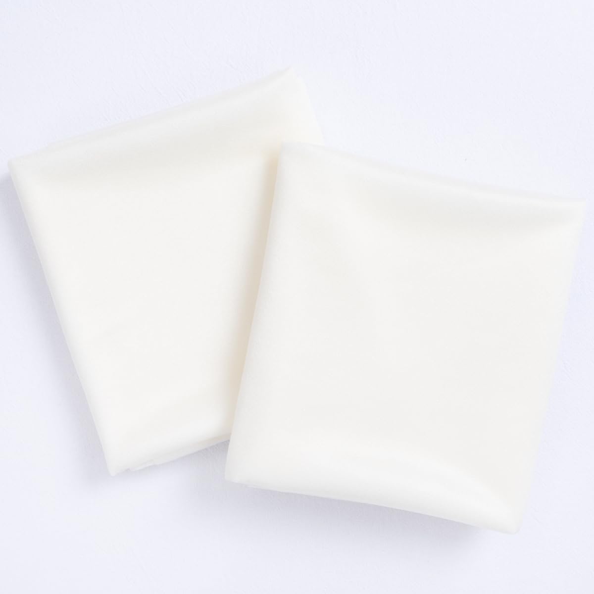 Socomi Ivory White fabric close-up highlights silky texture for elegant backdrops.