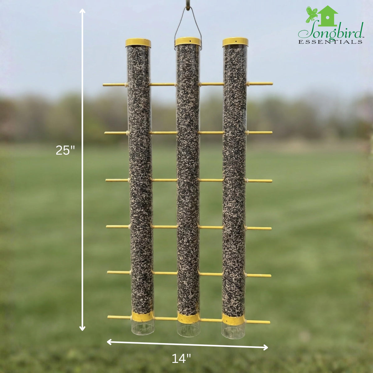 Songbird Essentials goldfinch feeder outdoors in a sunlit garden.