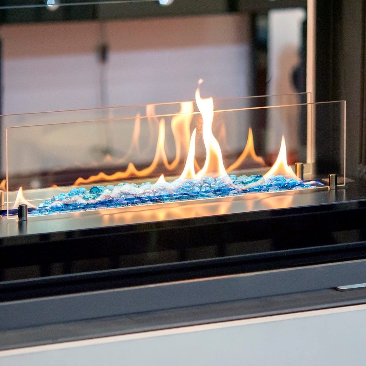 Stanbroil Caribbean Blue Luster fire glass drops in a fish tank for decorative shimmer