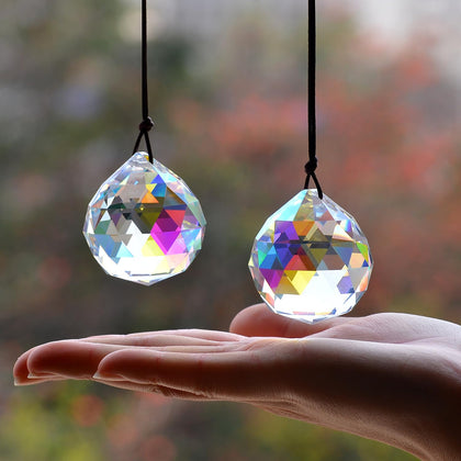 Stino ball crystal sun catcher prism in sunlit window casting rainbow sparkles.