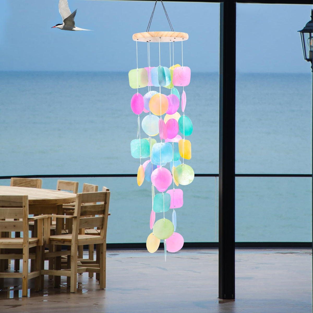 Taman outdoor wind chime showcases sunlit shells casting playful shadows
