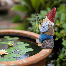 Teresa's Collections garden-edge scene gnome pairs with flowers for a whimsical focal point.