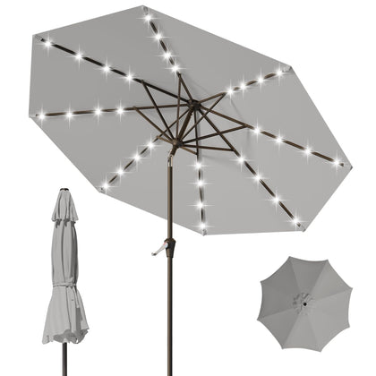Tobeos 9FT patio umbrella with solar LEDs lighting an outdoor table at dusk.