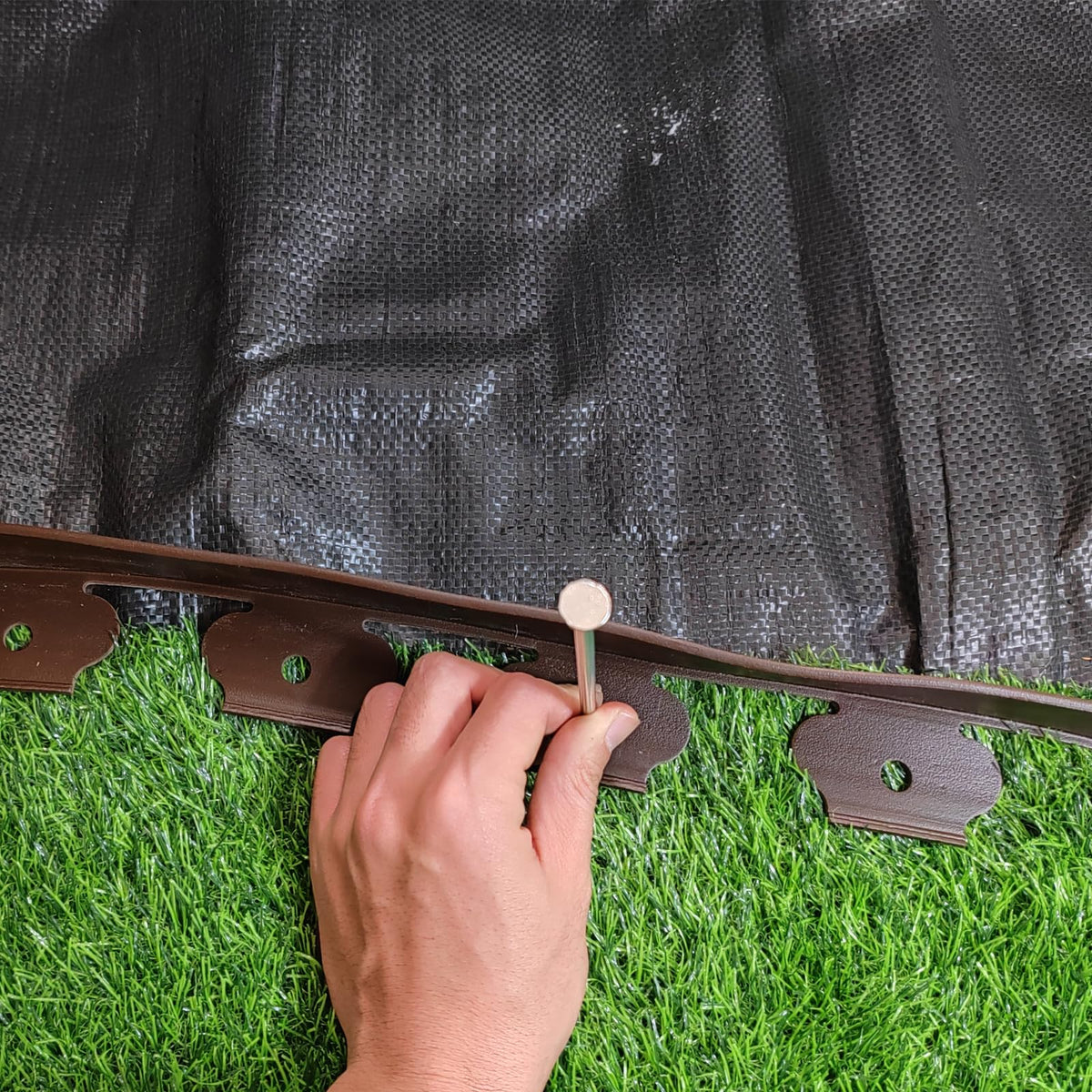 TPNEMGF weed fabric stakes anchor fabric to prevent movement.