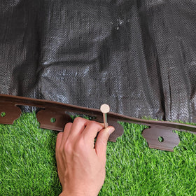 TPNEMGF weed fabric stakes anchor fabric to prevent movement.