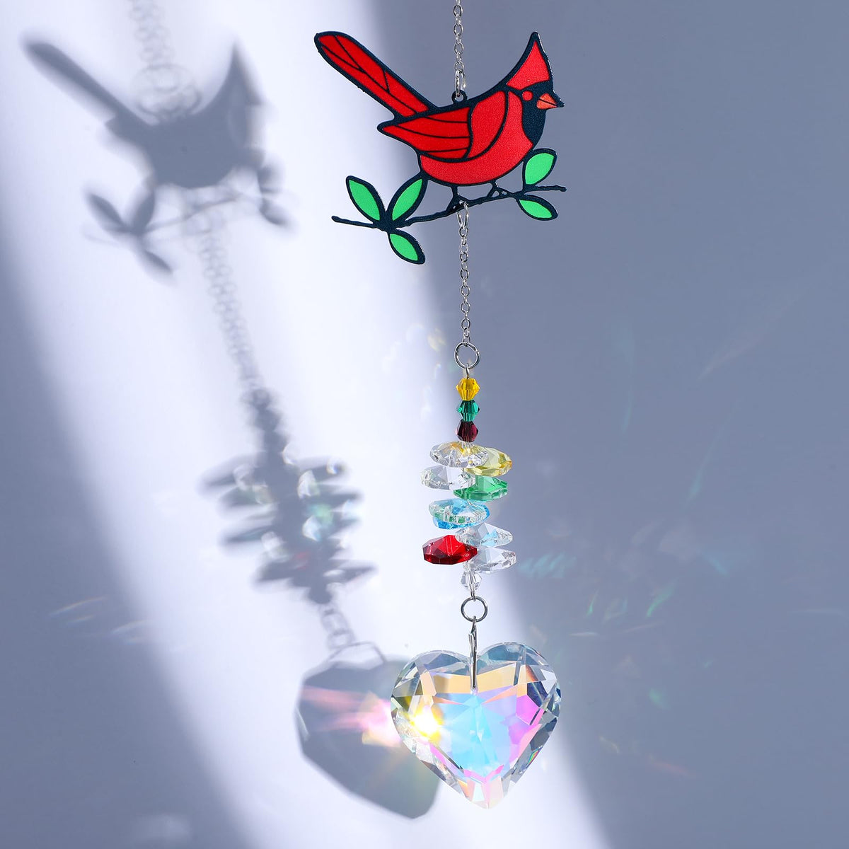 Tyqour red bird love pendant adds a playful focal point to sunlit spaces.
