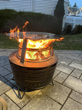 Uniflasy heat deflector set beside a cozy patio fire for a warm ambiance.