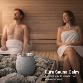 Veyro diffuser resting on sauna stones with steam rising.