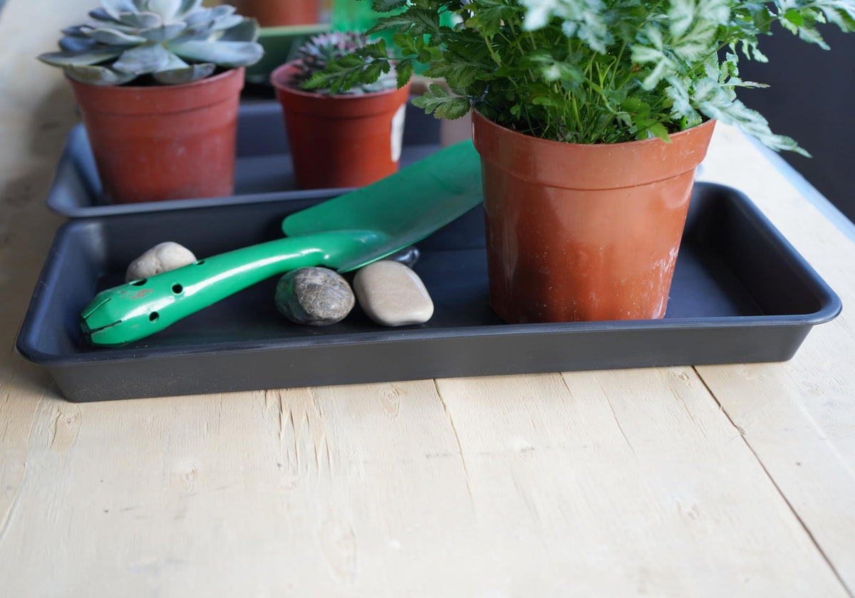 VUWEZ brown plastic plant saucer complements planters while catching overflow.