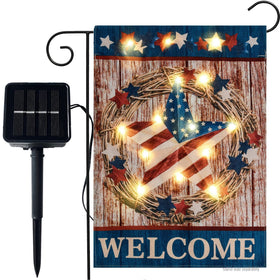 WDGG welcome flag with solar LED lights lighting a garden at dusk