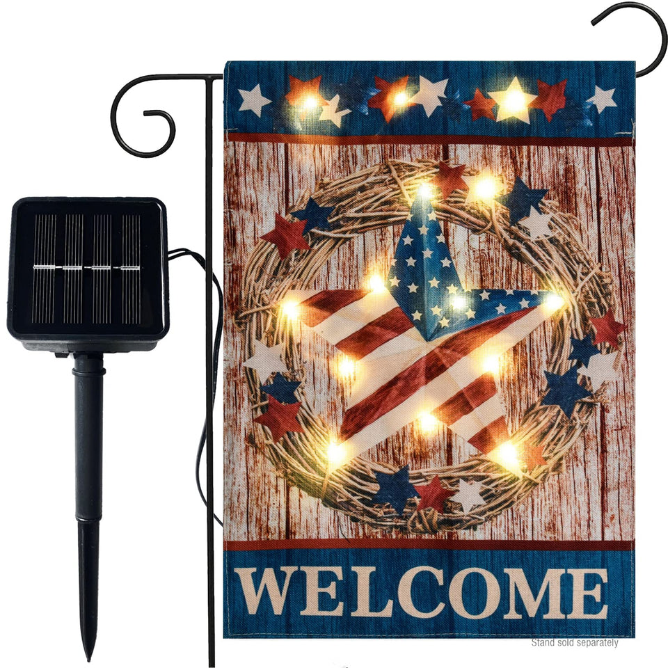 WDGG welcome flag with solar LED lights lighting a garden at dusk