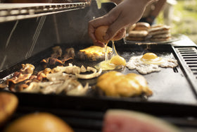 Weber Crafted eggs and vegetables sizzling on warp-resistant carbon steel.