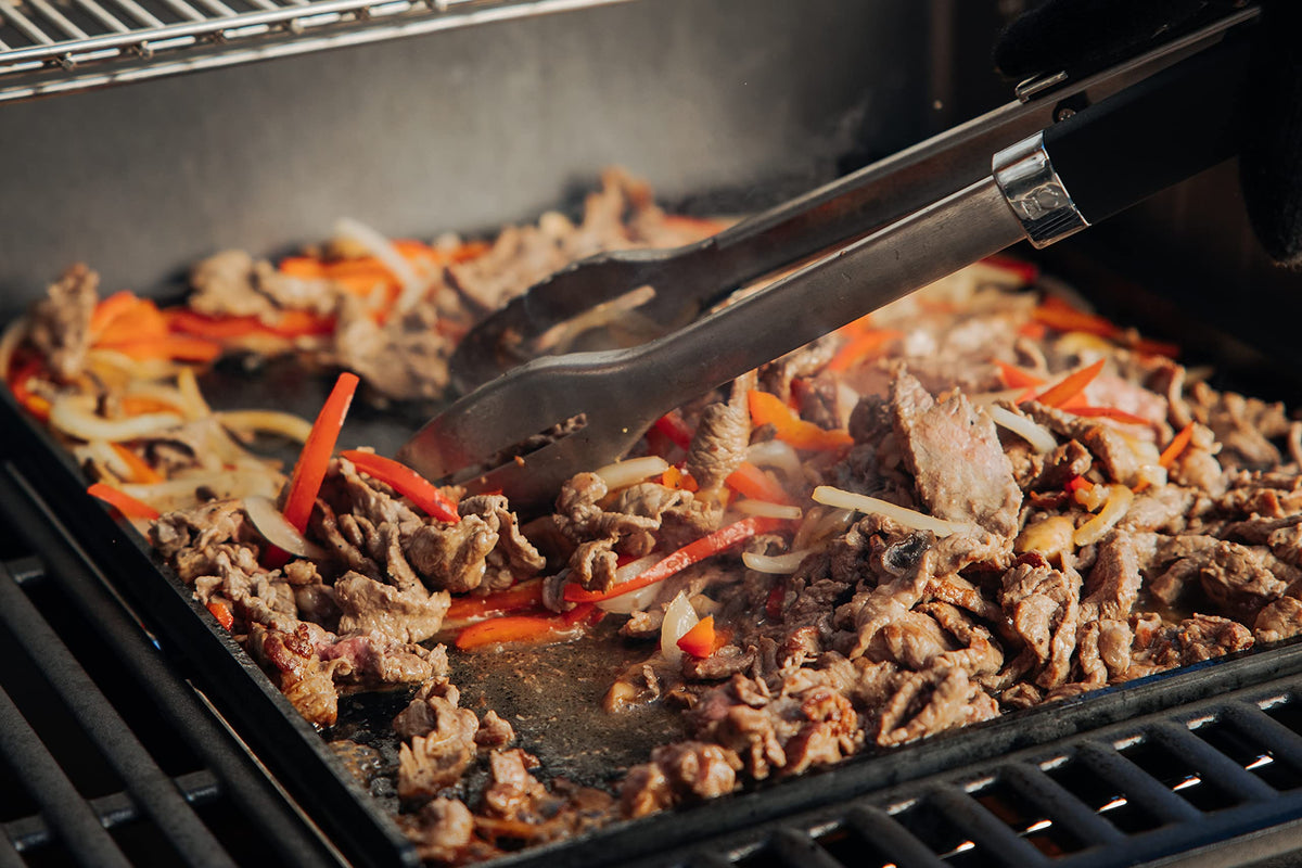 Weber Crafted fajitas sizzling on the flat-top surface.
