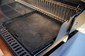Weber Crafted pancakes cooking on flat-top griddle outdoors.
