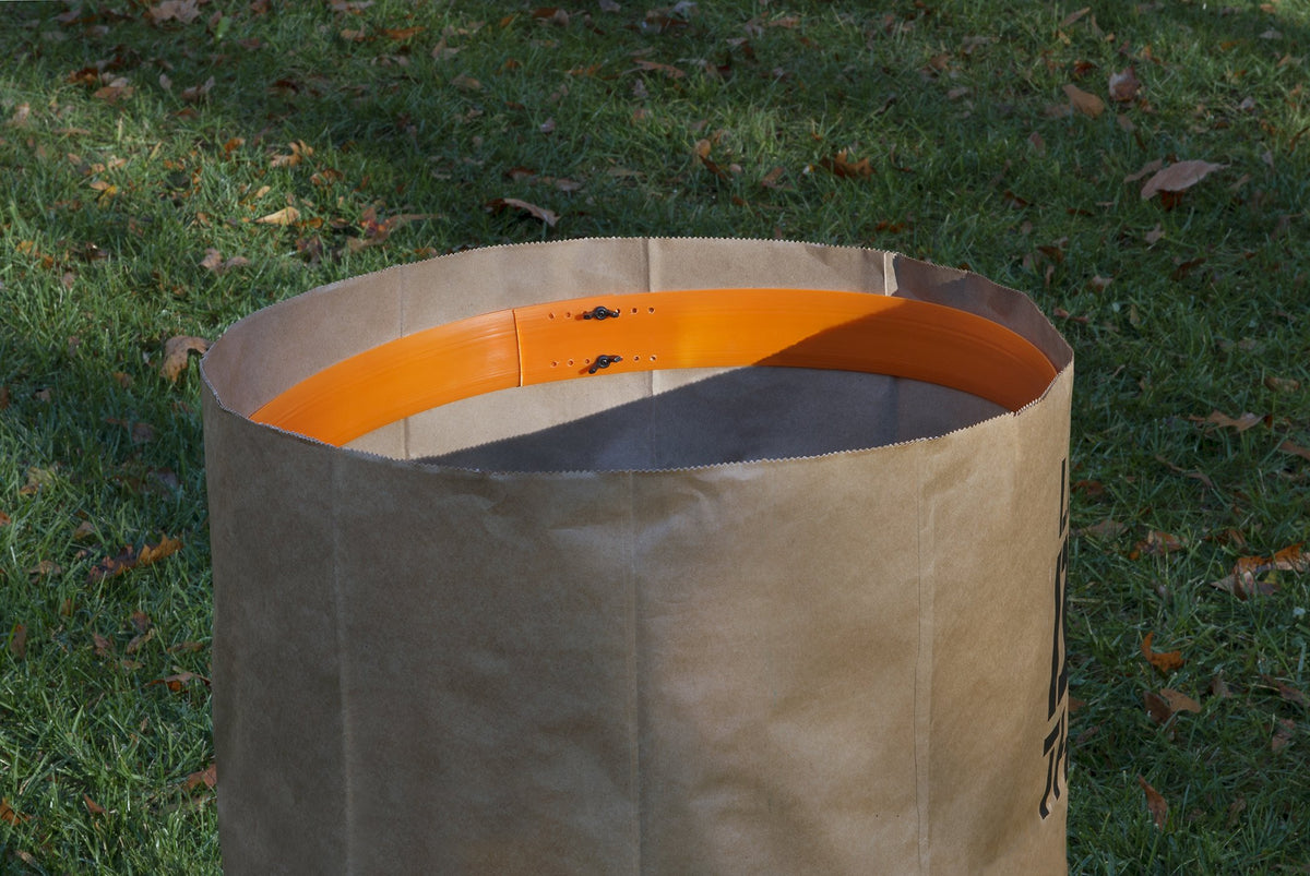 WORX bag holder stabilizes paper bags, preventing tipping during yard cleanup.