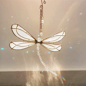 XinTX Dragonfly crystal suncatcher hanging by a sunny window creating rainbow highlights