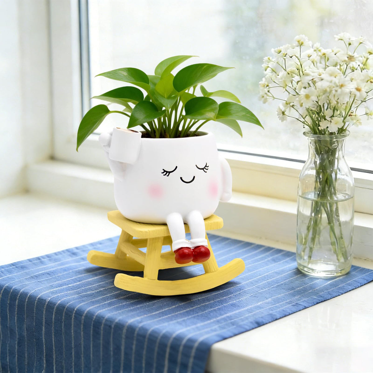 YOUOIVIA rocking-chair-face-planter with faux flowers adds charm.