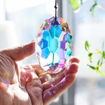 YU FENG AB coating crystal prism hanging in a sunlit window creates vivid rainbow reflections.