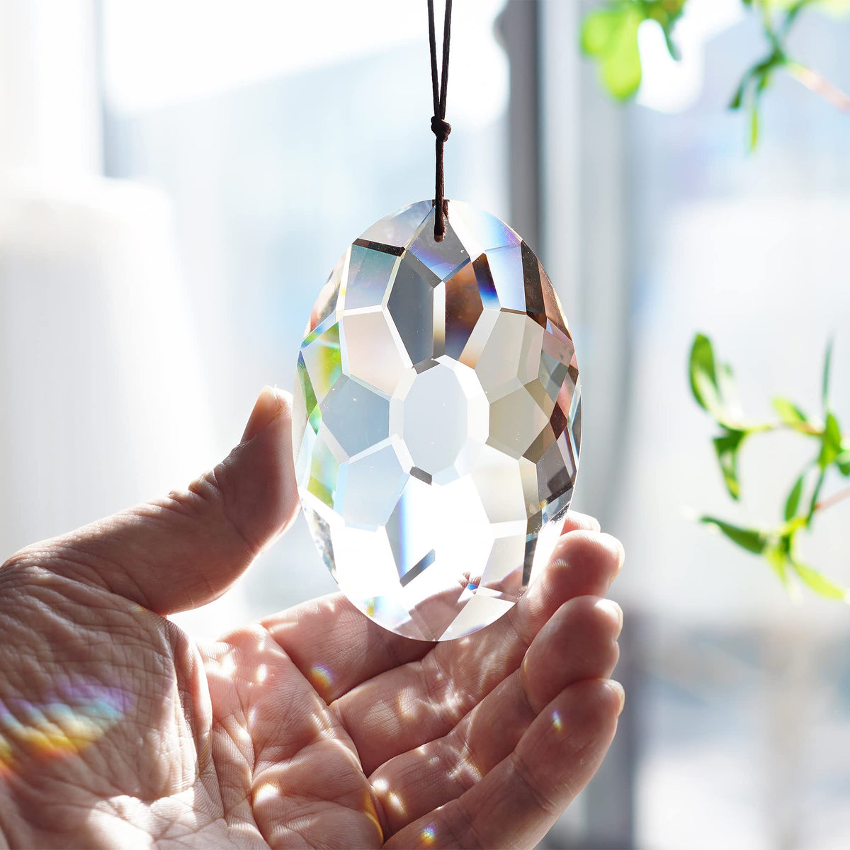 YU FENG crystal prism suncatcher in sunlight over windows