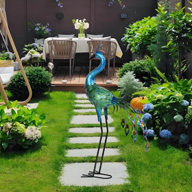 Ziowio peacock statue in garden path, enhances landscape with elegance.